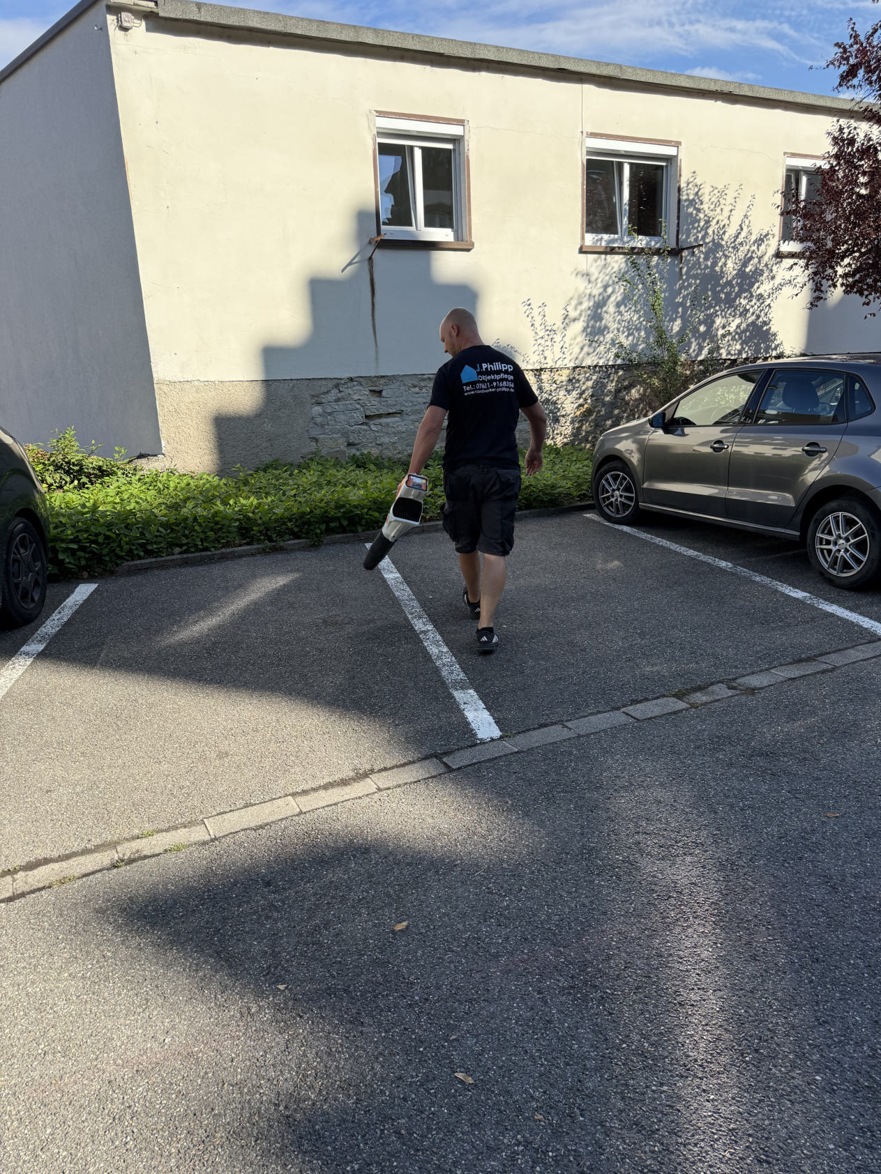 Josef Philipp bei der Pflege einer Parkplatzfläche mit einem Laubbläser